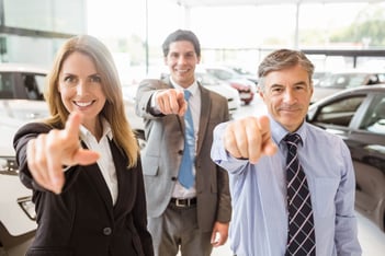 Car Salespeople Pointing towards Camera