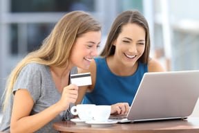 Two girls with laptop and credit card