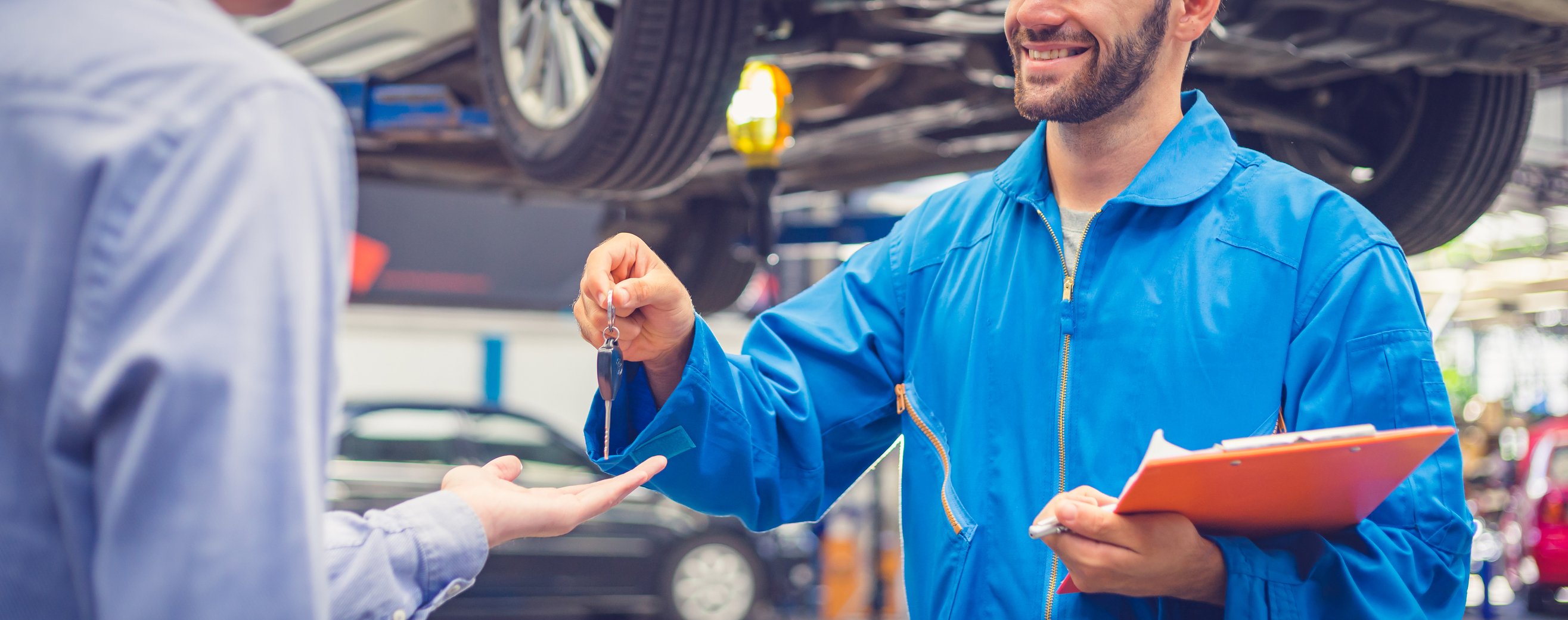 Mechanic hanging keys to customer