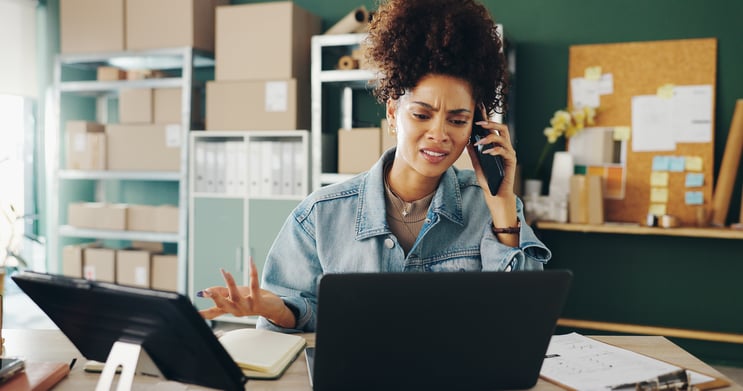 Business woman in her store/office, on the phone showing frustration.