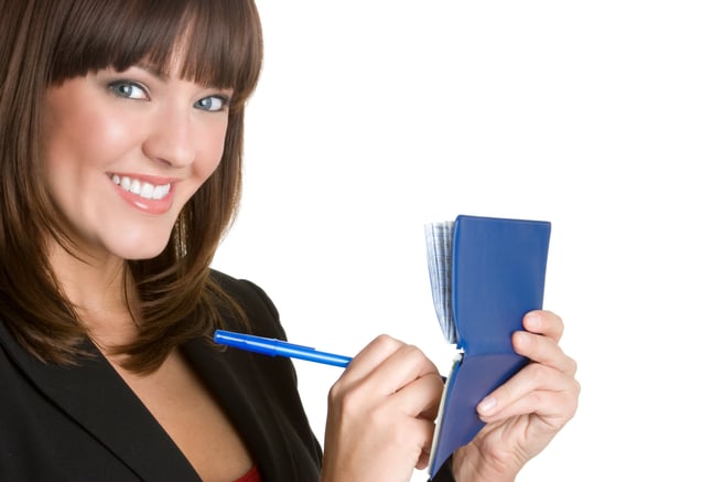 Woman smiling writing a check