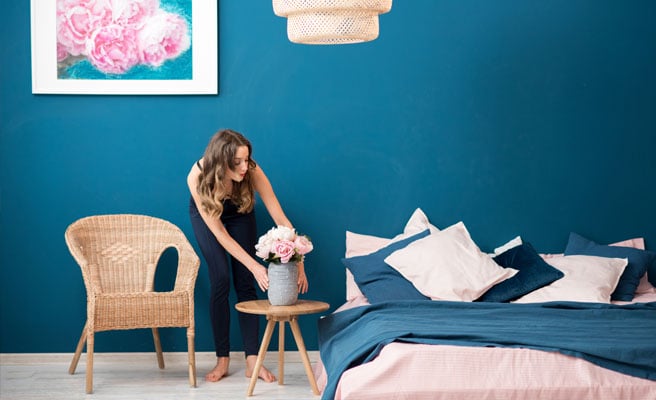 Woman placing flowers furnished room