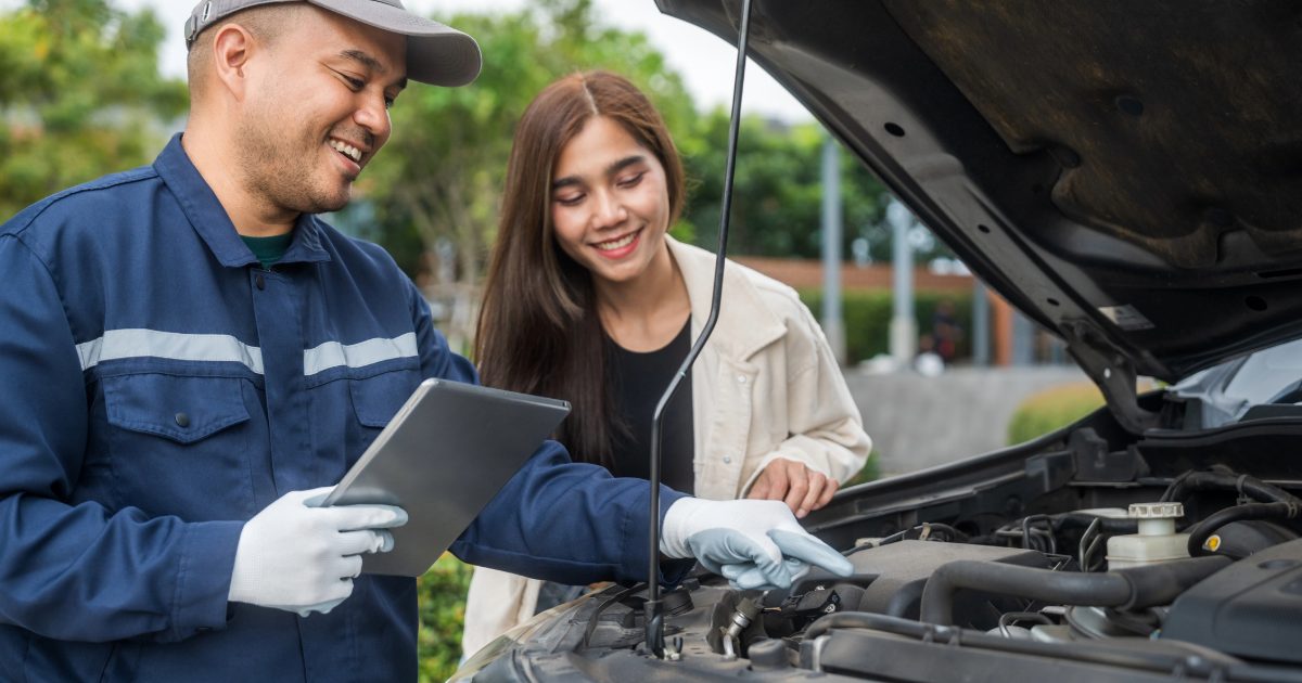 Dealership service tech repairing vehicle in customer's driveway. 