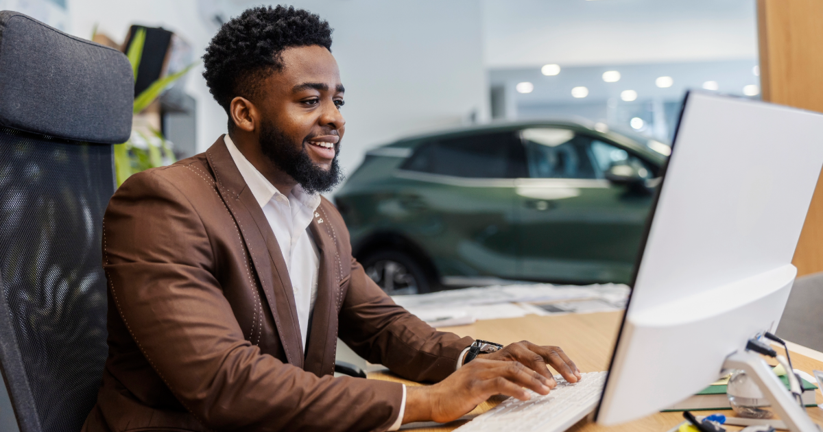 Controller working at a desk in an auto dealership. 