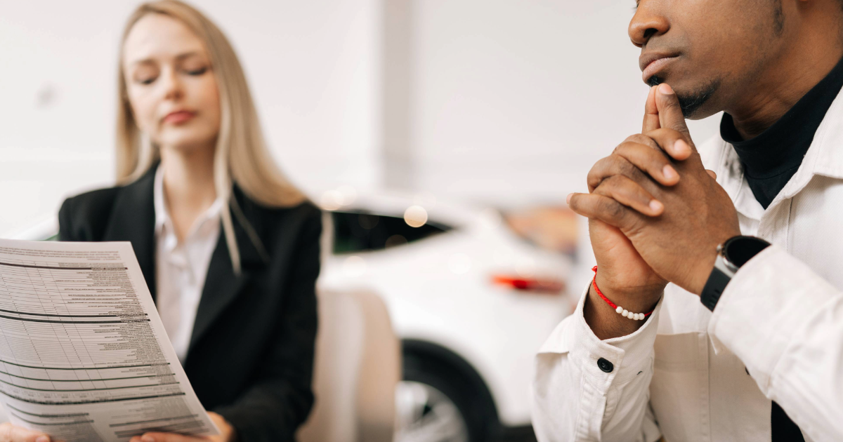 Two employees of Automotive Dealership going over paperwork.