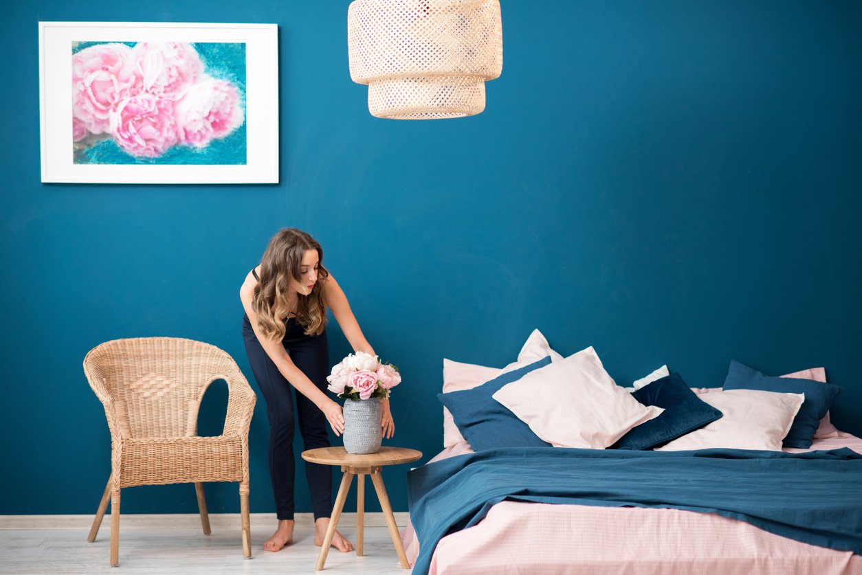 Woman placing flowers furnished room